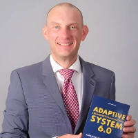 Cyrille C. Catel holding his Adaptive Organization & Management System 6.0 book